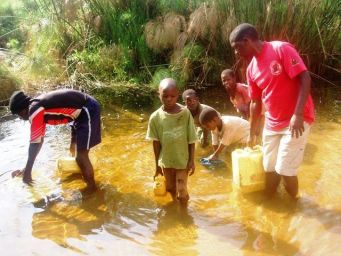 Shadrak with children of Mulungi Omu collecting water from a swamp.jpg