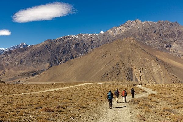 Trekkers in Nepal - Four trekkers walking in annapurna landscape, Nepal